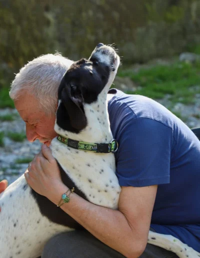 Volontario che abbraccia un cane